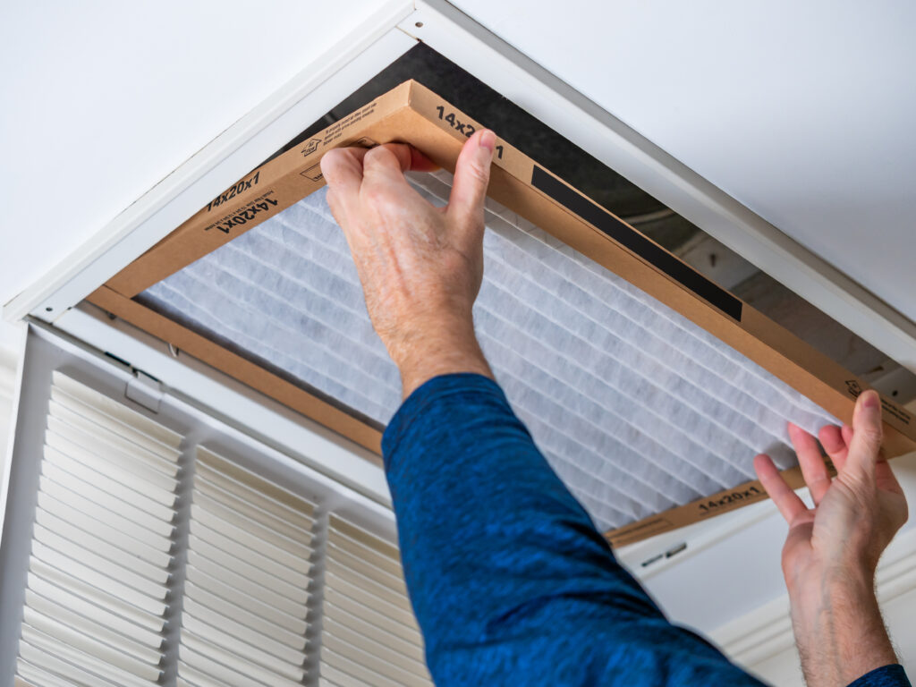 HVAC technician replacing a home air filter in Duarte