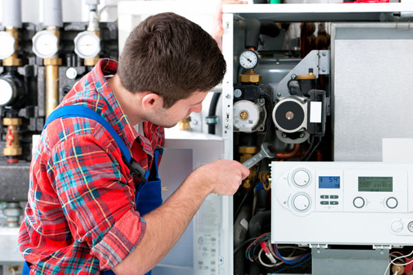 Heating technician repairing boiler controls in Duarte