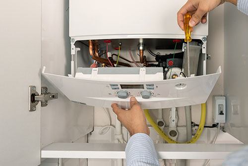 Heating technician repairing a residential boiler in Duarte
