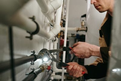 Technician inspecting commercial plumbing pipes in Duarte
