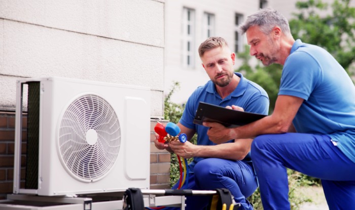 HVAC technicians installing an outdoor air conditioning unit in Duarte
